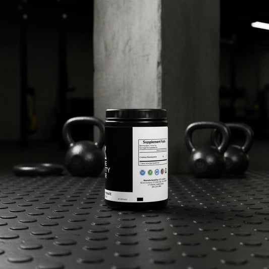 Bote de creatina negra Core Gravity en un gimnasio industrial con pesas y columnas de concreto desenfocadas.